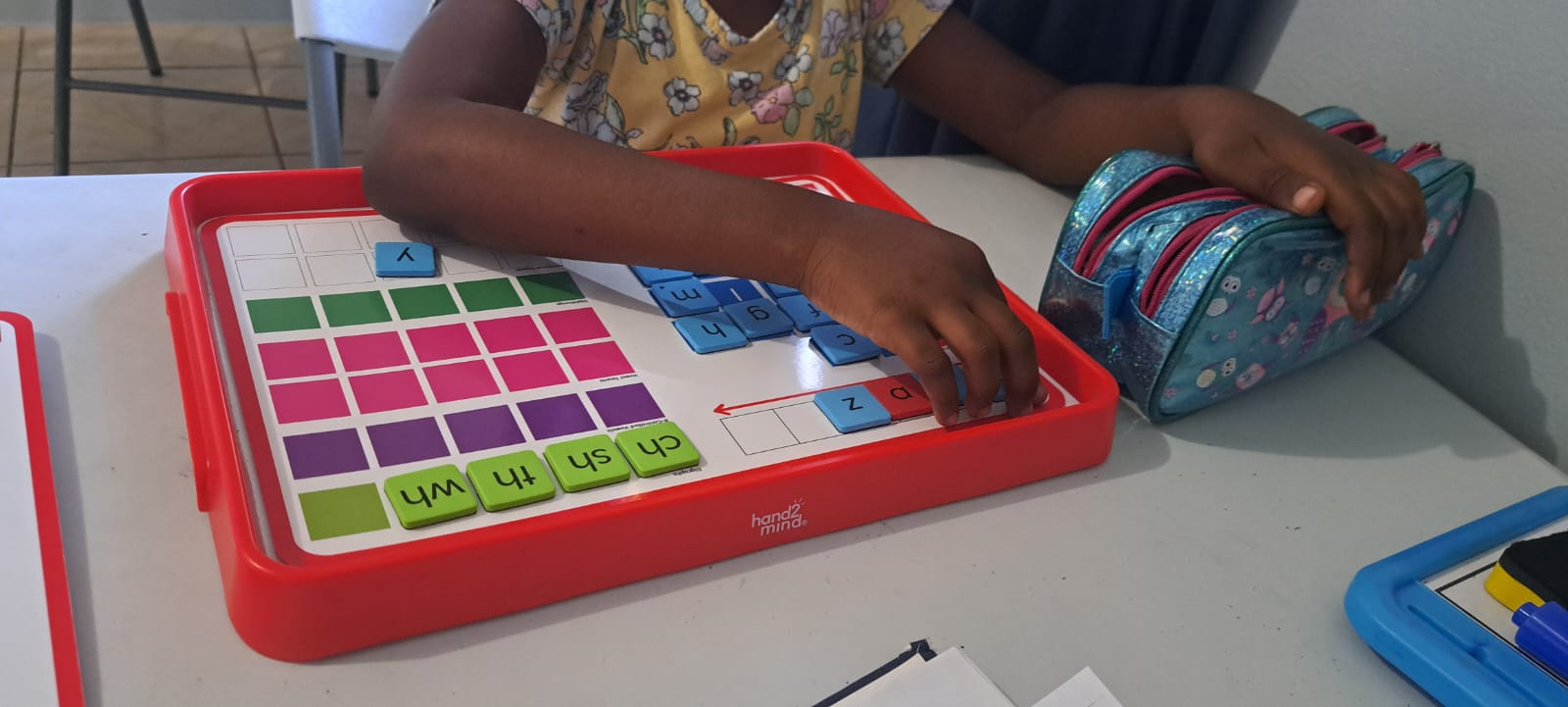 A student working with OG phonogram tiles at Think-Top Educational Institute